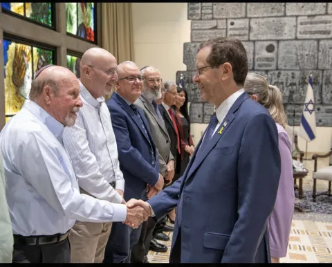 תמונה של פרופ' פרוסט לחוץ את ידו של נשיא המדינה הרצוג